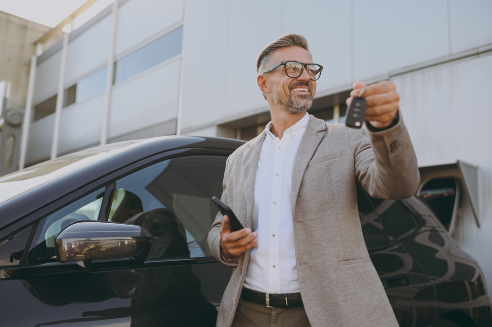 Adult man is happy that he already got his new car with key