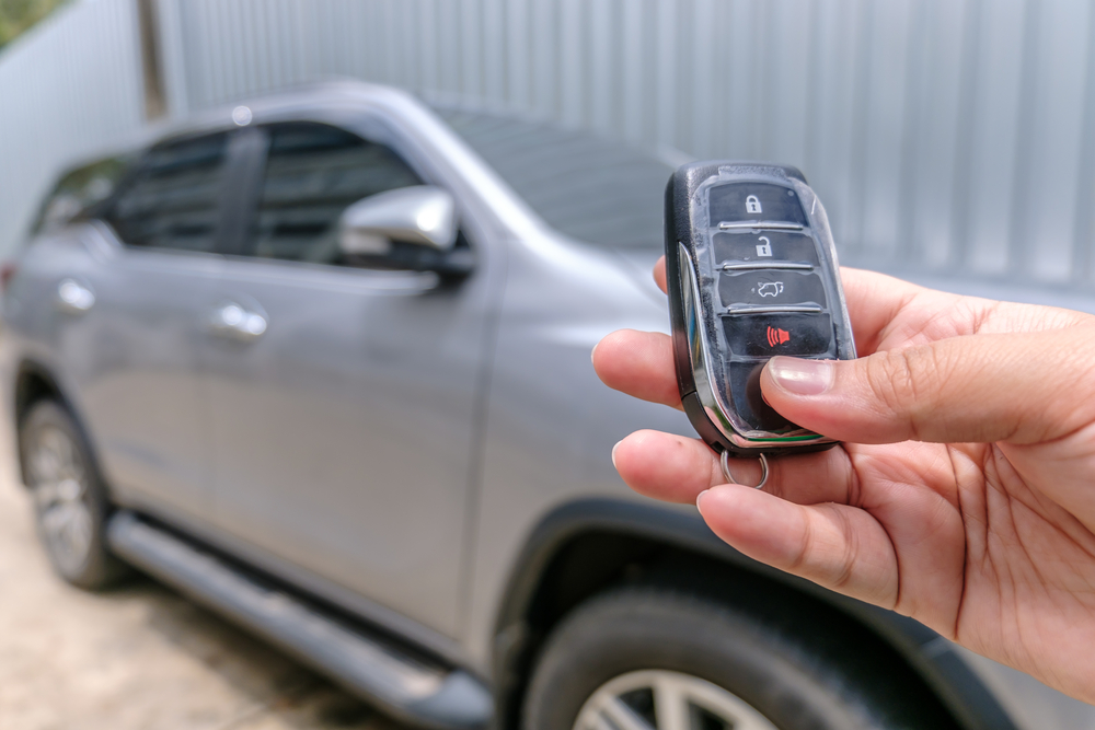 A hand is testing the remote car starter